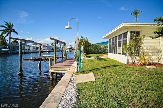 dock area with a yard, a water view, and boat lift