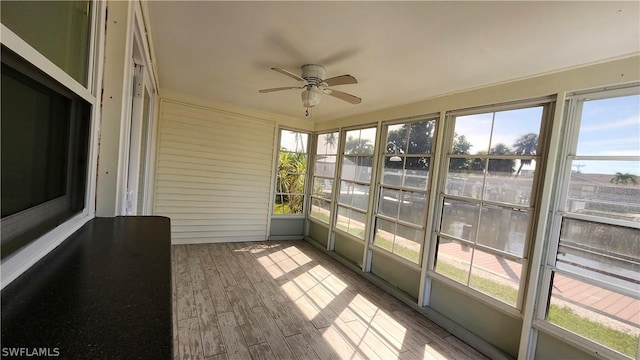 unfurnished sunroom featuring a ceiling fan