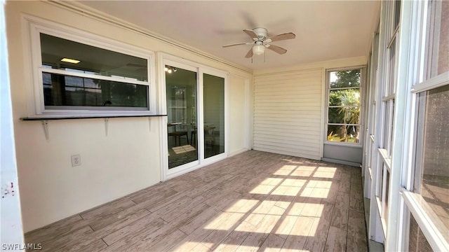 unfurnished sunroom featuring ceiling fan