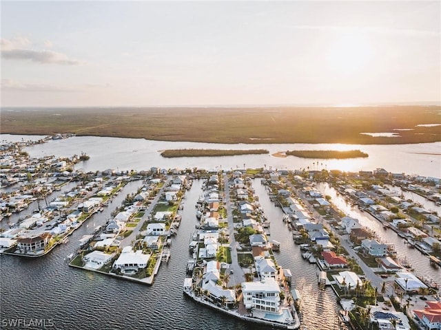 aerial view at dusk with a residential view and a water view