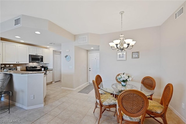 tiled dining area featuring a chandelier