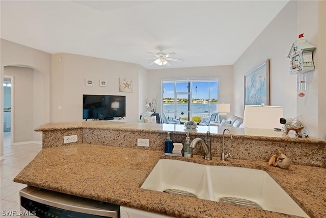 kitchen featuring ceiling fan, dishwasher, sink, light stone countertops, and light tile patterned floors