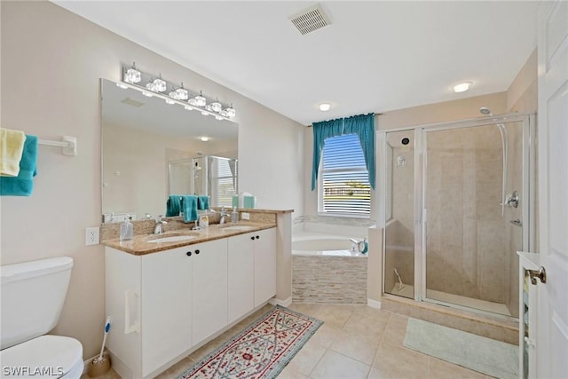 full bathroom featuring tile patterned floors, vanity, shower with separate bathtub, and toilet