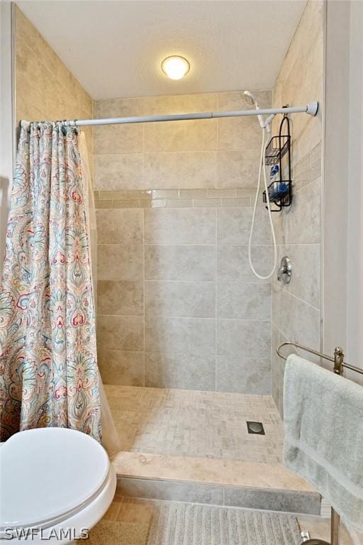 bathroom with a shower with shower curtain and toilet