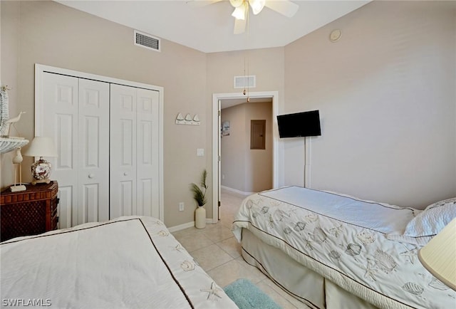 tiled bedroom with electric panel, a closet, and ceiling fan