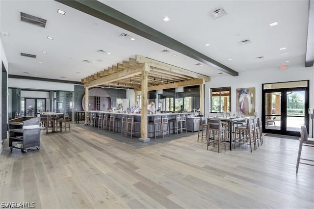 dining space with french doors, beam ceiling, hardwood / wood-style flooring, and indoor bar