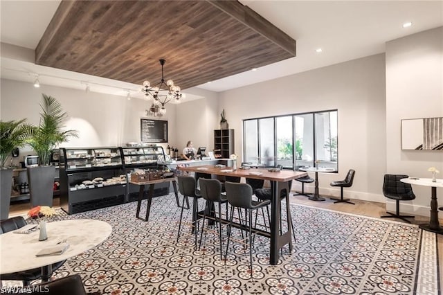 dining space with wooden ceiling, an inviting chandelier, and track lighting