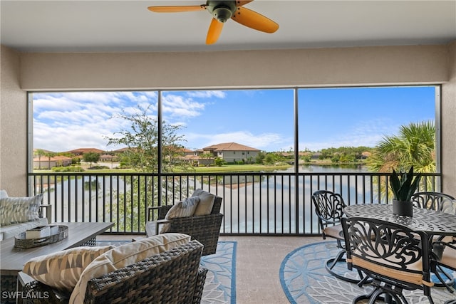 sunroom with a water view and ceiling fan