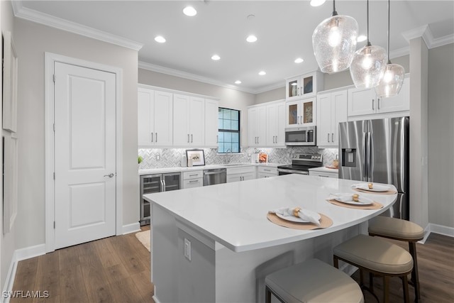 kitchen featuring wine cooler, appliances with stainless steel finishes, a kitchen island, and white cabinets