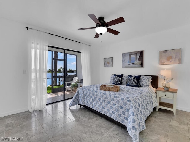 bedroom featuring access to outside, a water view, and ceiling fan