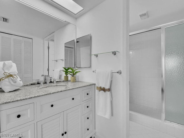 bathroom featuring tile patterned flooring, vanity, and a shower with door