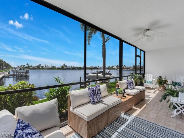 sunroom featuring ceiling fan and a water view