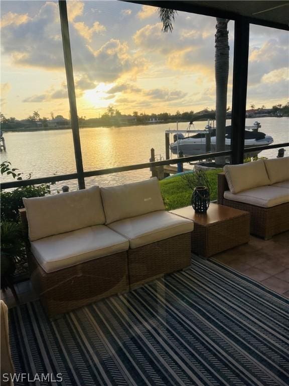 patio terrace at dusk with a water view and an outdoor hangout area