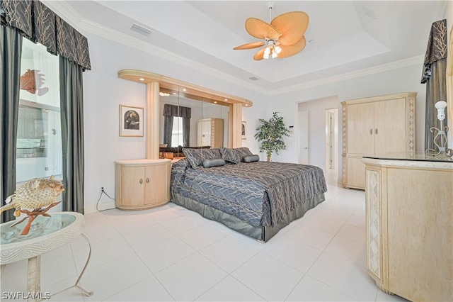 bedroom featuring light tile patterned floors, visible vents, ceiling fan, a tray ceiling, and crown molding