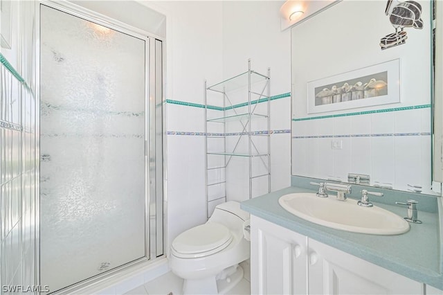 bathroom featuring toilet, vanity, a shower stall, and tile walls