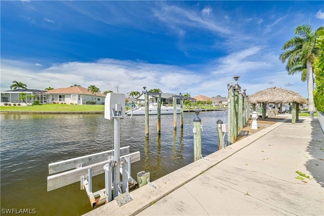 view of dock with a water view, boat lift, and a residential view