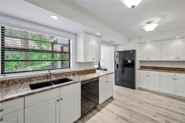 kitchen with dark stone counters, white cabinetry, sink, and black appliances