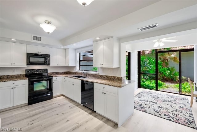 kitchen with dark stone counters, ceiling fan, sink, black appliances, and white cabinetry