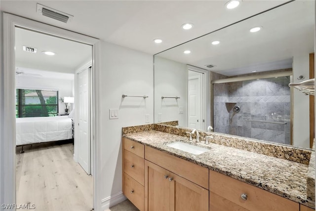 bathroom with a shower with door, vanity, and hardwood / wood-style floors