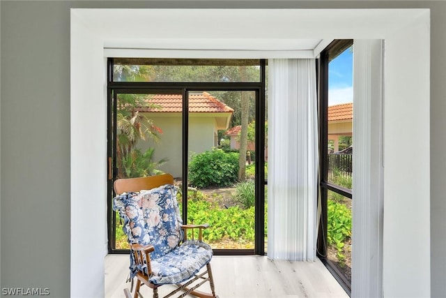 doorway to outside with light hardwood / wood-style flooring, a healthy amount of sunlight, and a wall of windows