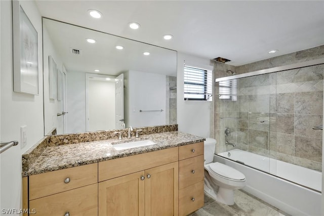 full bathroom featuring shower / bath combination with glass door, vanity, and toilet