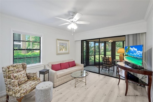 living room featuring ceiling fan, light wood-type flooring, and ornamental molding