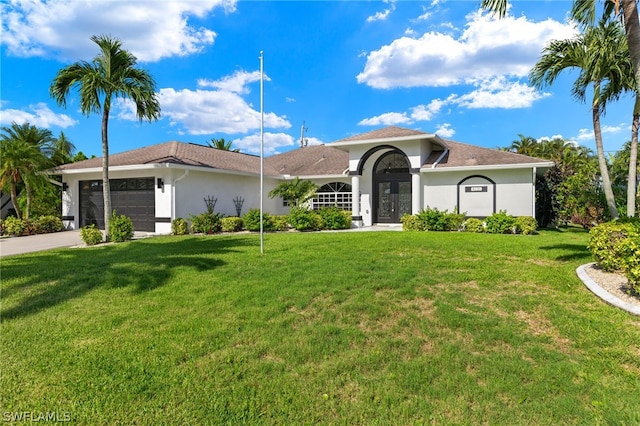 mediterranean / spanish-style house featuring french doors, a front yard, and a garage