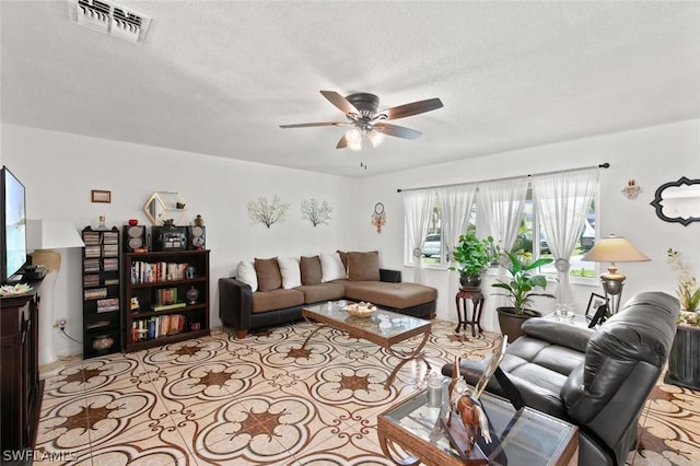 living room featuring ceiling fan and a textured ceiling