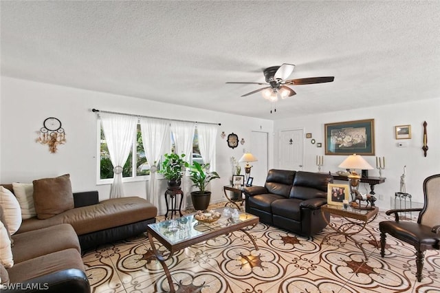 living room with ceiling fan and a textured ceiling