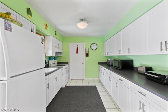 kitchen with light tile patterned floors, white cabinets, and white appliances