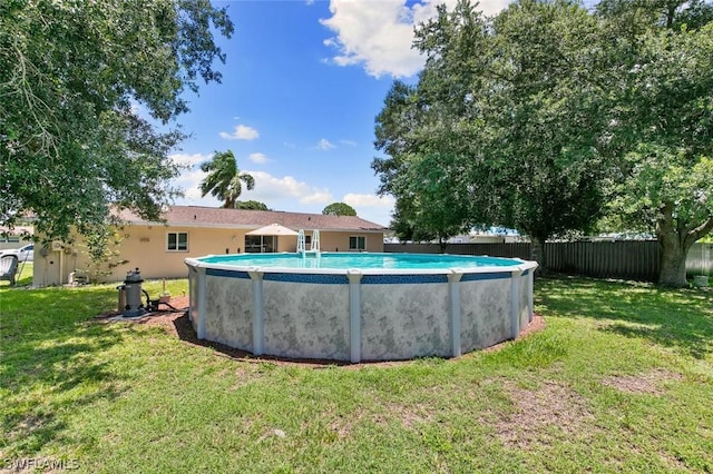 view of swimming pool with a lawn