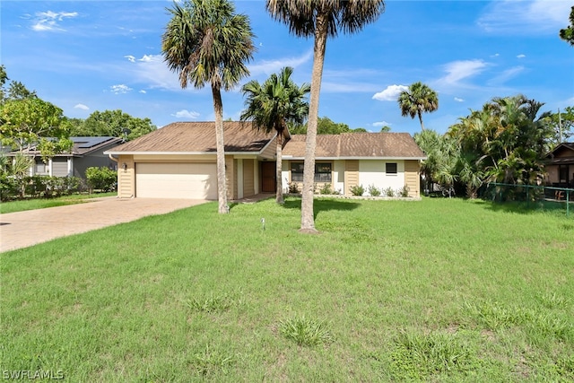 ranch-style home with a garage, solar panels, and a front lawn