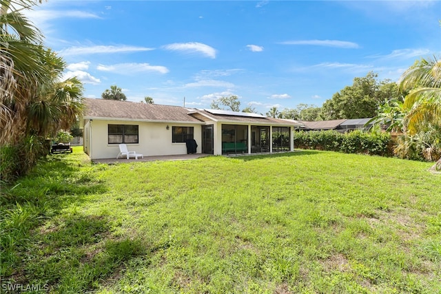 rear view of property featuring a sunroom and a yard