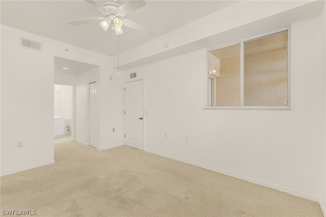 empty room with ceiling fan and light carpet