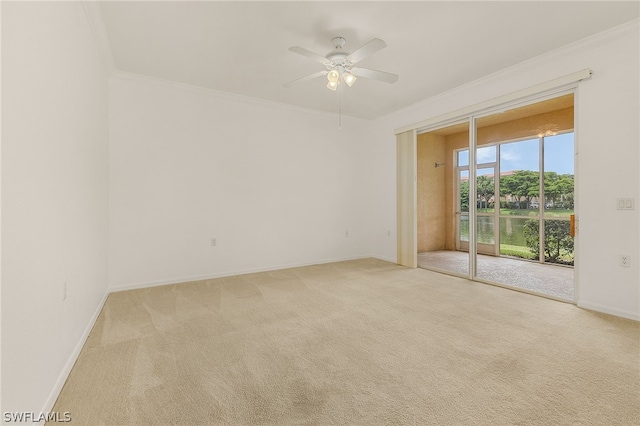 empty room featuring light carpet, crown molding, and ceiling fan