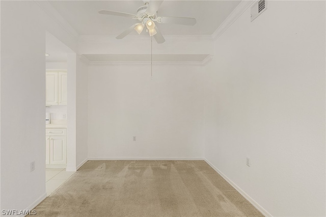 spare room featuring ornamental molding, light colored carpet, and ceiling fan