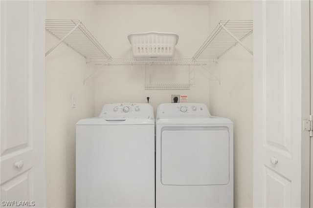 clothes washing area with separate washer and dryer