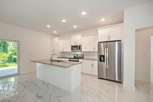 kitchen featuring appliances with stainless steel finishes, white cabinets, a kitchen island with sink, and sink