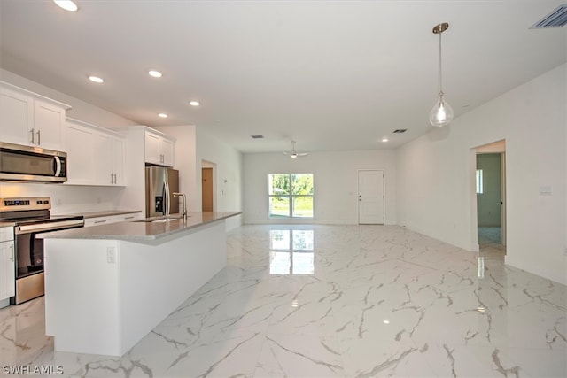 kitchen featuring sink, white cabinets, hanging light fixtures, a center island with sink, and appliances with stainless steel finishes