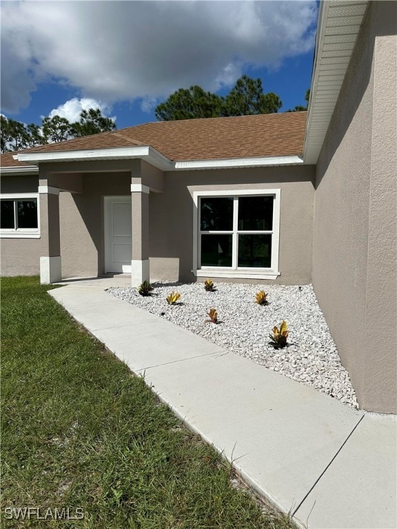 view of exterior entry with a lawn