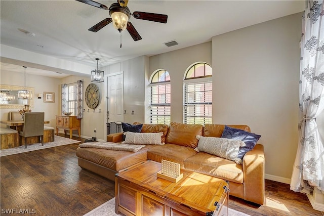 living room featuring hardwood / wood-style floors, ceiling fan with notable chandelier, and a wealth of natural light