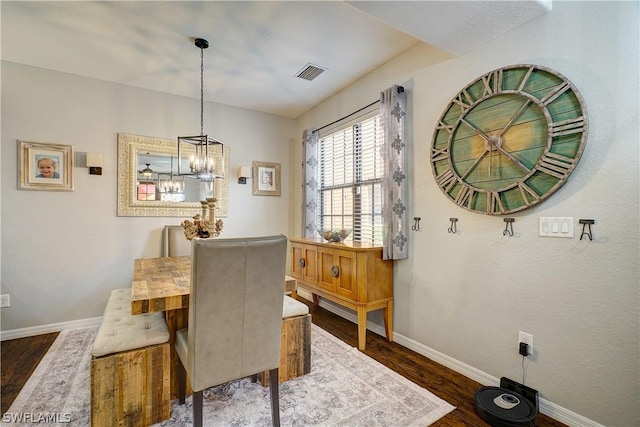 dining area featuring dark hardwood / wood-style flooring and a notable chandelier