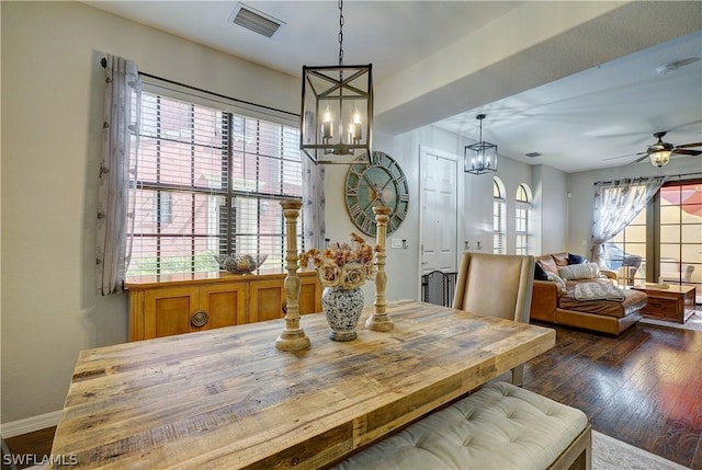 dining space featuring ceiling fan with notable chandelier and dark hardwood / wood-style floors