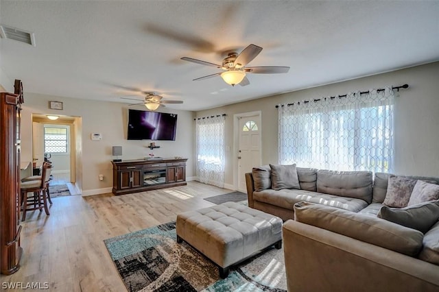 living room featuring ceiling fan and light hardwood / wood-style floors