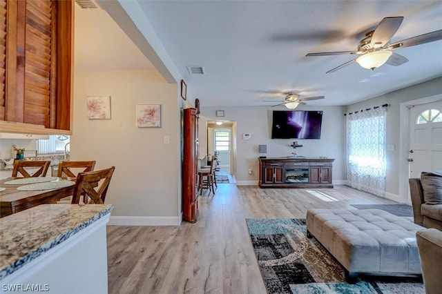 living room featuring light hardwood / wood-style flooring and ceiling fan