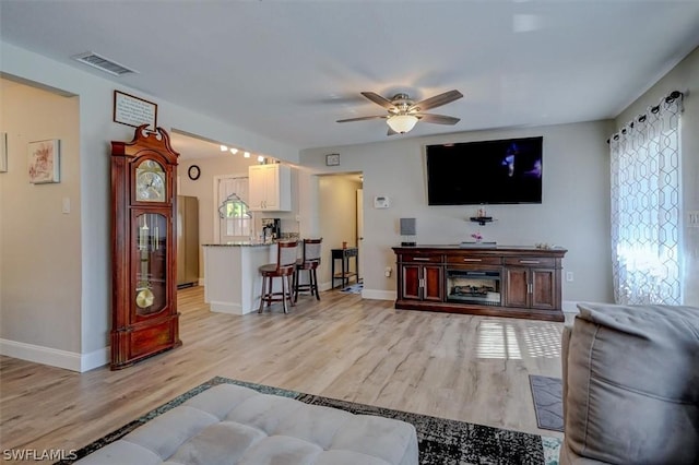 living room featuring ceiling fan and light hardwood / wood-style floors