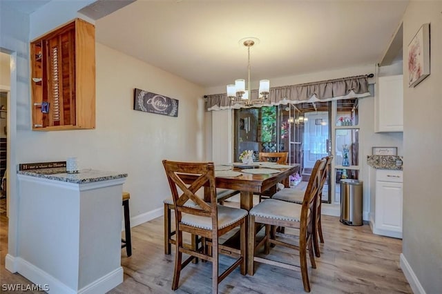 dining area featuring a notable chandelier and light wood-type flooring