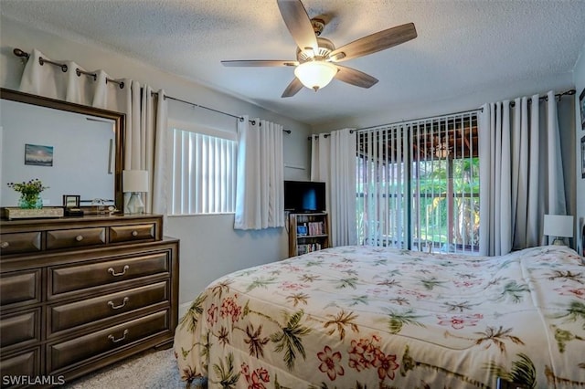 bedroom featuring ceiling fan, light carpet, and a textured ceiling