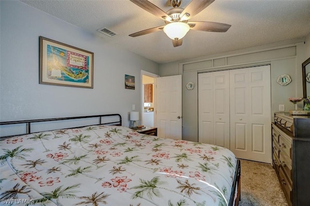 carpeted bedroom featuring ceiling fan, a textured ceiling, and a closet