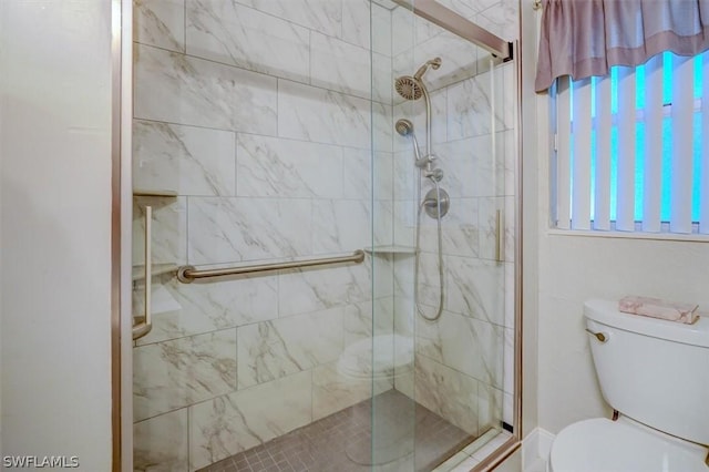 bathroom featuring toilet and a shower with door